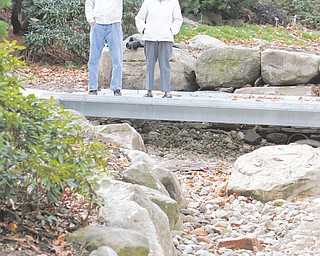 Jack Anderson and Barbara Dean look over the new bridge and drainage area along the new path in Fellows Riverside Gardens of Mill Creek MetroParks. Anderson designed the handicapped accessible path that goes through the gardens’ native woodlands display.