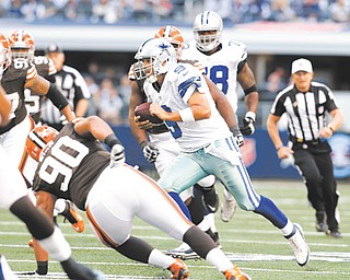 Dallas Cowboys quarterback Tony Romo (9) scrambles as Cleveland Browns defensive tackle Billy Winn (90) gives chase during an NFL game Sunday in Arlington, Texas. The Cowboys won in overtime 23-20.