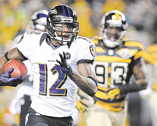 Baltimore Ravens’ Jacoby Jones (12) returns a punt past Pittsburgh Steelers Jason Worilds (93) on his way to a touchdown in the first quarter of an NFL football game on Sunday in Pittsburgh.
