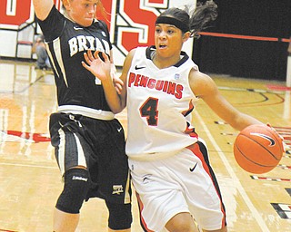 Youngstown State freshman guard Shar’Rae Davis (4) drives around Bryant’s Katie Whittington (11) during the
first half of a game Sunday at Beeghly Center. Davis scored 23 points and had five steals and four assists in
the Penguins’ 75-59 victory. The YSU women’s basketball team is off to a 3-0 start.