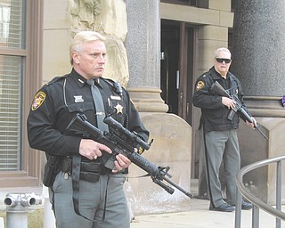 Lt. Pete Lucic, left, and Maj. Harold Firster of the Trumbull County Sheriff’s Office stand guard in front of the county courthouse Monday afternoon. They were preparing for two men to appear for their first hearing in the Nov. 11 shooting death of Marco Dukes, 32.