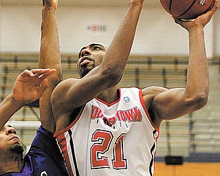 Youngstown State’s Damian Eargle (21) puts in a layup to reach 1,000 points for his career with the Penguins
as James Madison’s Enoch Hood (1) defends during the second half of Tuesday’s game at Duquesne University’s
Palumbo Center. Eargle finished the game with 17 points, six rebounds and six blocked shots in YSU’s 69-68
loss.