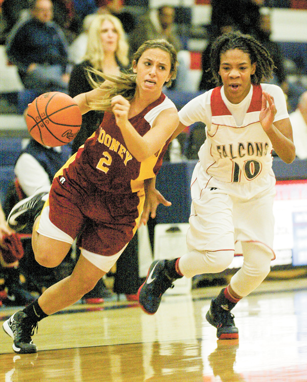Mooney’s Jamie DiDomenico (2) drives around Brenda Thompson (10) of Fitch during first half action Monday at Fitch. The Falcons ran past the Cardinals, 63-37, in the first game of the season for both teams.
