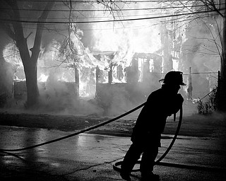 Youngstown fire fighters attempt to put out the massive fire of a vacant house located off Market Street in Youngstown.
