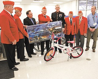 The local Marine Corps Reserve Toys for Tots program, coordinated by the 4th Landing Support Equipment Company at the Youngstown Air Reserve Station in Vienna, received a $5,000 check from Cafaro Corp. on Tuesday at the Kmart Super Center in Niles. Harry Dampf of Canfield, fourth from left, headed a Marine Corps League campaign to raise money to buy 115 bicycles to be distributed as part of Toys for Tots. From left to right are: Leo Connelly Jr. and Frank Sokol, both League members; Joe Bell, Cafaro Corp.; Dampf; Marine Gunnery Sgt. Brian Zeilfang, co-coordinator of the local Toys for Tots program; Bruce Kirkland and Sam Lanza, League members; and Jake Aron, Kmart store manager.
