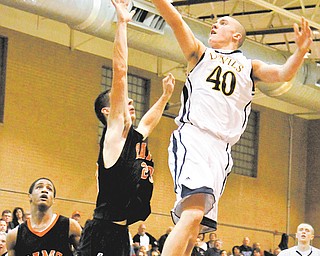 McDonald’s Matt Seitz (40) goes up for a shot as Mineral Ridge’s Nathan Palmer (23) defends Tuesday night. McDonald won, 82-73.