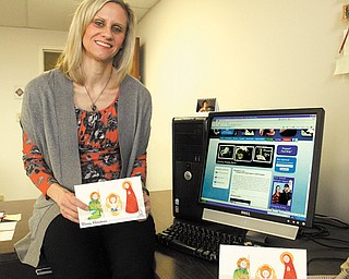 Rachel A. Hrbolich, associate director of social services at Catholic Charities of the Diocese of Youngstown, shows the Christmas card featuring a depiction of the Holy Family that is being sent as a thank-you to donors. Catholic Charities is promoting its online Christmas Gifting Program as a way to remember someone with a gift that helps someone in need.