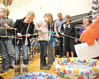 Fifth-grade students at Springfield Intermediate School catch numbered fish with magnetic poles from inflatable kiddie pools, then calculate the mean, median and mode of numbers. The activity was part of a camping-themed Math Night on Thursday in the school gym.