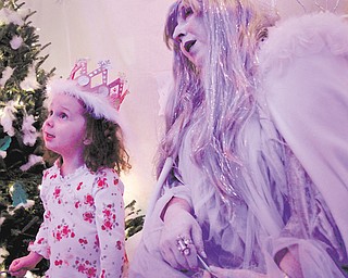 Norah Baker, 3, of Hubbard, makes a wish for snow with Snow Queen Barbara Root during Winter Nights on Sunday at Mill Creek MetroParks’ Fellows Riverside Gardens.