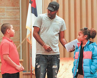 Director Gerald Hamilton works with Milton Apolinnaris and Annise Colon as they rehearse the roles of Joseph and Mary. Rehearsals began Monday for kids who participate in Neighborhood Ministries’ after-school programs. At the West Side Community Center, 45 children will gather over the next three days to tell the Christmas story.