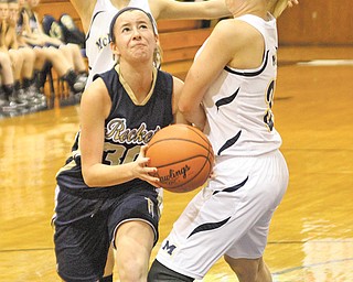 Madison Opritza of Lowellville drives toward the basket as Alyssa Streb of McDonald plays defense during their game Monday night at McDonald. The visiting Rockets won, 61-35.