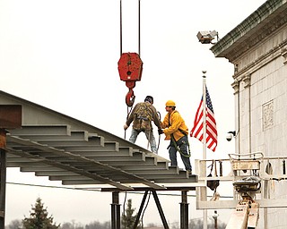 Ironworkers Local 207 members John Gallagher of Youngstown, left, and Tim Evans of Boardman, working for Diamond Steel of Boardman, assemble a new walkway between the Butler Institute of American Art and Butler North. The bridge will be a walkway gallery and will display the museum’s historic glass-bell collection.