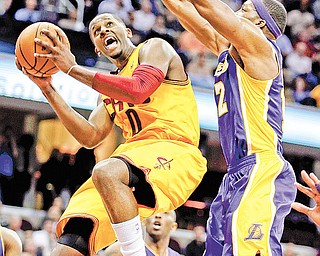 Cleveland Cavaliers’ C.J. Miles, left, goes in for a shot against Los Angeles Lakers’ Dwight Howard in the second
quarter of a game Tuesday in Cleveland.