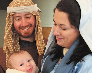 Evan Grope is all smiles in his role as baby Jesus as his parents, Michael and Sarah Grope, share the happy
moment. The family is participating in the live Nativity, “Journey to Bethlehem,” planned Saturday at
Disciples Christian Church in Boardman.