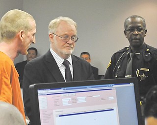 Daniel R. Oldfield, 27, of Salem, left, who is charged with felonious assault with a revolver, makes his initial appearance in Sebring court Thursday with his lawyer, Jeffrey Jakmides of Alliance, as Edward Mitchell, a Mahoning County deputy sheriff , provides security.