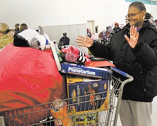 Vickie Adkins of Youngstown shops for Christmas gifts for her grandchildren, Kei’Sean, Nakaia and Tre’Sean McRae, at the Mahoning County Salvation Army gift distribution. About 2,000 children from 1,500 families are slated to receive Christmas gifts through the program, which continued today for preregistered families.