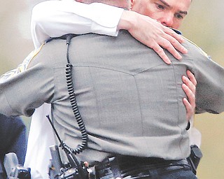 Police officers console each other outside the funeral service for 6-year-old Noah Pozner in Fairfield, Conn., on Monday.