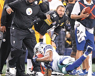 Cowboys cornerback Brandon Carr intercepts a pass by Steelers quarterback Ben Roethlisberger in front of Pittsburgh head coach Mike Tomlin during overtime in Sunday’s game at Cowboys Stadium in Arlington, Texas. Carr got up and raced down the sideline to the one yard line to set up the Cowboys’ game-winning field goal and jeopardize the Steelers’ playoff chances.