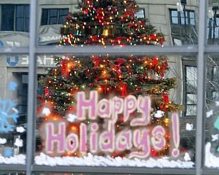 William D. Lewis The Vindicator The city Christmas tree is reflected in hte window of a downtown building.