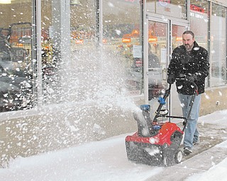 Jared Pekar, sales manager at Do Cut in Boardman, uses a snow blower in front on his store along state Route 224. Area retailers credit Wednesday’s storm for a spike in the sale of such machines.