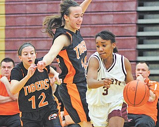 Liberty’s Shamara Golden (3) tries to drive around Newton Falls defenders Brooke Barreca (14) and Alissa
Abraham (12) during the first half of their All American Conference basketball game Thursday at Liberty High
School. The Tigers downed the Leopards, 59-30.