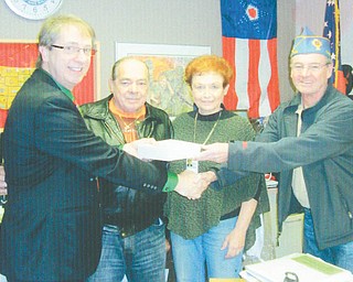 Funds to benefit needy veterans and their families were raised at the annual reverse raffle and basket auction sponsored by Catholic War Veterans Post 1292 of Youngstown. Mark Bell, left, director of the Veterans Clinic on Belmont Avenue, and Lori Stone, clinic volunteer, accepted the $1,200 donation from Al Bisker, second from left, Post 1292 trustee and Gary Barnes, post commander. 
