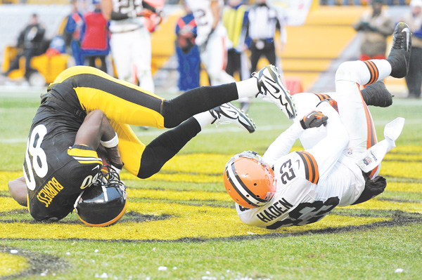 Pittsburgh Steelers wide receiver Plaxico Burress tumbles in the end zone with Cleveland Browns cornerback Joe Haden for a fourth-quarter touchdown in Sunday’s game in Pittsburgh. The Steelers topped the Browns, 24-10, with nothing at stake but bragging rights.