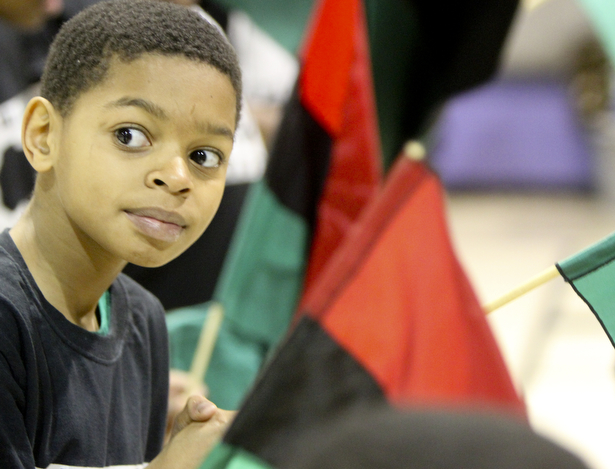William D Leiws the Vindicator Tyler Wagner,11, holds an african flag during Kwanzaa celebration Tuesday at McGuffey Centre.
