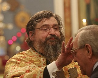 William D Leewis The Vindicator Rev Milan Medakovic annoints a parishioner with oil during Christmas eve service Sunday 1-7-12 at Holy Trinity Serbian Orthodox Church in Youngstown.