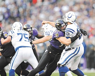 Indianapolis Colts quarterback Andrew Luck is hit by Baltimore Ravens outside linebacker Paul Kruger as right guard Mike McGlynn, a graduate of Austintown Fitch High, blocks during the second half of their AFC wild
card playoff game Sunday. The Ravens won, 24-9.