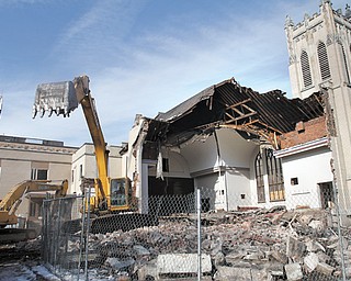 Crews began tearing down Pilgrim Collegiate Church on the Youngstown State University campus Tuesday. The area will be used, at least initially, for green space — opening up the view to Jones Hall, the original building on campus.