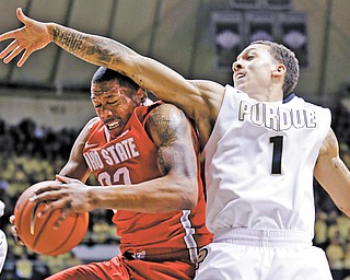 Ohio State guard Lenzelle Smith Jr., left, grabs a rebound under Purdue guard Anthony Johnson in the first half of a game in West Lafayette, Ind., on Tuesday.