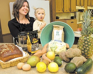 Kathryn Hatch, a member of Glenwood Christian Fellowship in Boardman and promoter of its cafe, Sounds and Grounds, talks about the benefits of organic foods. She’s holding her 19-month-old daughter, Talia Pearl. The cafe will be the site of a fundraiser Saturday for Goodness Grows.