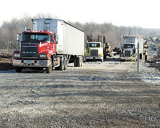 Trucks move in on the unbuilt part of Lanterman Road in Austintown that will be renamed once the Hollywood Slots at Mahoning Valley Race Course is built.