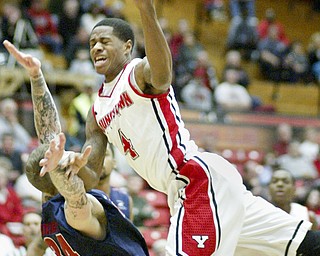 Youngstown State’s Shawn Amiker (4) collides with Detroit’s Nick Minnerath (34), who is charged with a foul, during the first half of Thursday’s game at YSU’s Beeghly Center. The Titans routed the Penguins, 101-60.