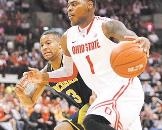Ohio State’s DeShaun Thomas (1) drives down the court as Michigan’s Trey Burke (3) tries to keep up during Sunday’s NCAA basketball game in Columbus. Thomas posted 20 points for the No. 15 Buckeyes, who handed the No. 2 Wolverines their first loss with a 56-53 win.