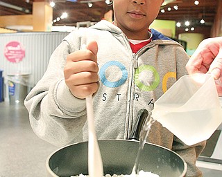 Conovas Crawford, 8, of Youngstown, mixes ingredients to make glue at OH WOW! The Roger & Gloria Jones Children’s Center for Science & Technology in downtown Youngstown.