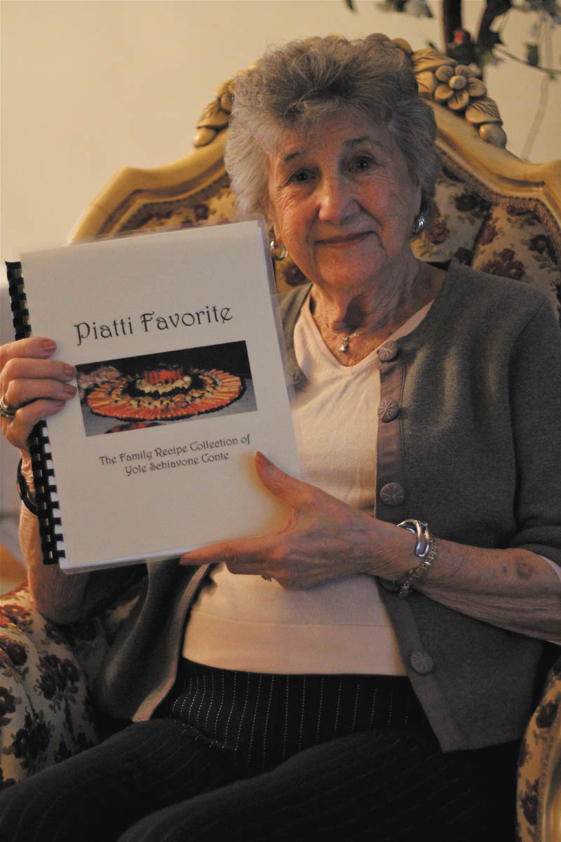  Yole Conte of Austintown holds the cookbook she put together with old family recipes handed down from generation to generation.