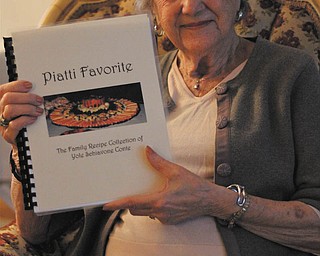 Yole Conte of Austintown holds the cookbook she put together with old family recipes handed down from generation to generation.