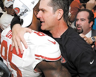 San Francisco 49ers head coach Jim Harbaugh, right, hugs Vernon Davis after defeating the Atlanta Falcons on Sunday in the NFC Championship game in Atlanta.