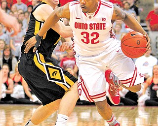 Ohio State’s Lenzelle Smith (32) moves the ball past Iowa’s Mike Gesell during the second half of a game Tuesday in Columbus. Ohio State won 72-63.