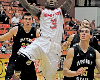 Youngstown State’s Kendrick Perry (3) goes up for a layup around Wright State defenders Kendall Griffin (15) during Wednesday’s Horizon League game at YSU’s Beeghly Center. Perry had his first double-double of the season with 14 points and 10 rebounds as the Penguins downed the Raiders, 68-61.