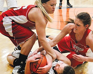 From left, Columbiana’s Khylea Fullum, Lowellville’s Rachel Durbin and Columbiana’s Megan Cutlip wrestle for the basketball during Monday’s showdown.