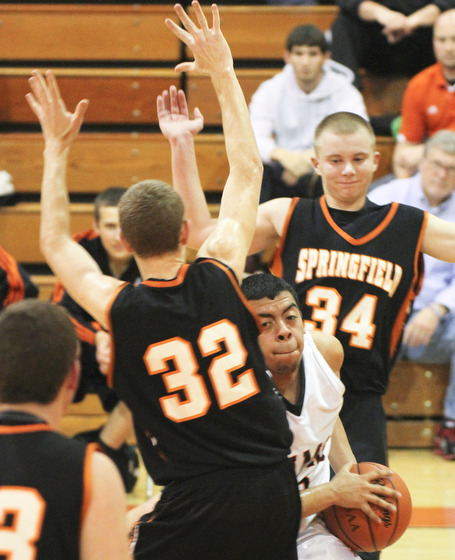 William d Lewis the Vindicatore  Springfield's Jared McTigue(32) and Brandon Chamberlain(34) sandwich Ridges Brandon Perkinsduring 1 rst half action Tuesday at Ridge.