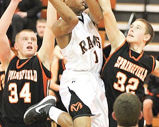 Springfield’s Jared McTigue (32) tries to block Mineral Ridge’s Corey Phillips (1) during an Inter Tri-County Tier One game Tuesday in Mineral Ridge. The Tigers edged the Rams in overtime, 58-54.