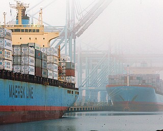 In this Dec. 5, 2012, photo, containers are unloaded from cargo ships at the Port of Los Angeles. The U.S. economy shrank unexpectedly in the October-December quarter of 2012, at an annual rate of 0.1 percent.