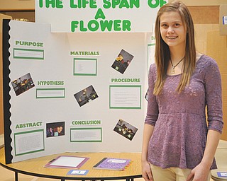 Lexxi Haluska, an eighth-grader at St. Joseph and Immaculate Heart of Mary School, poses in front of her science-fair project. Sixth- and eighth-graders presented their projects Wednesday for multiple judges.
