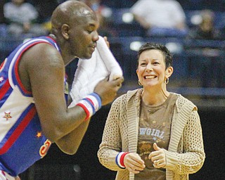 The Harlem Globetrotters’ “Big Easy” Lofton (52) wipes the sweat off his face before getting a kiss from
fan Denise Stoneman of Boardman during Wednesday’s exhibition basketball game against the Global Select at the Covelli Centre in Youngstown.
