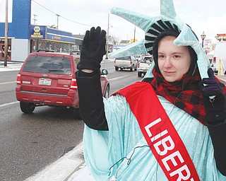 Mary Jones, of McDonald, dons a Statue of Liberty costume outside of Liberty Tax Service in Girard. Jones is one of several “guerilla marketers” the business uses to advertise. The human statues stand outside most of
the Liberty offices in the U.S.