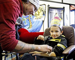 Nick West, another employee at the studio, gives 6-year-old Isaiah Howley a temporary tattoo of a skull on his birthday.